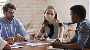 Concentrated teammates listening to coworker ideas at office.