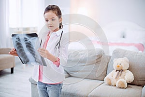 Concentrated thoughtful girl examining radiography