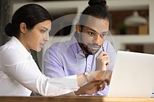 Concentrated two mixed race employees working on computer.