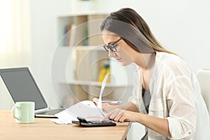 Concentrated woman doing accounting at home
