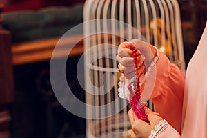 Concentrated woman praying wearing rosary beads. Namaste. Close up hands.