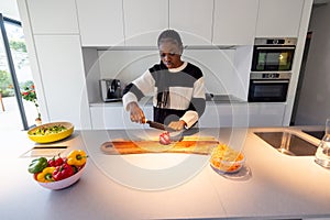 Concentrated Woman Preparing Fresh Salad in Sleek Kitchen