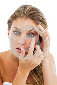 Concentrated woman putting a contact lens