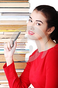 Concentrated woman sitting with stack of books