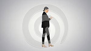 Concentrated woman in a suit writing business ideas in her notep