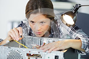 concentrated woman technician fixing computer