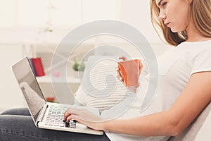 Concentrated woman typing on laptop, closeup