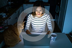 Concentrated woman working late hours with her laptop