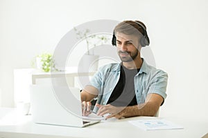 Concentrated worker wearing headphones listening to webinar at l photo