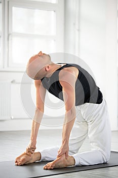 concentrated yoga man in trance, doing exercises of meditationg, yoga pose on knees