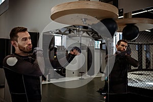 Concentrated boxer honing skills on speed bag in boxing gym photo