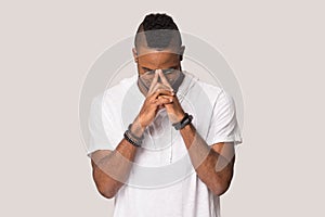 Concentrated young African American man thinking, praying