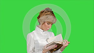 Concentrated young business woman holding and reading book on a Green Screen, Chroma Key