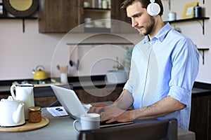 Concentrated young freelancer businessman using laptop for video conferance, working remotely online at home