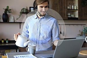 Concentrated young freelancer businessman using laptop for video conferance, working remotely online at home