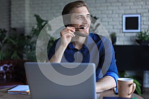 Concentrated young freelancer businessman using laptop for video conferance, working remotely online at home