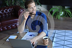 Concentrated young freelancer businessman using laptop for video conferance, working remotely online at home.