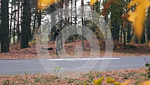 Concentrated young guy in helmet and sports sunglasses intensive pedaling on road bike off road. Professional cyclist training bef