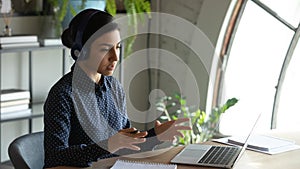 Concentrated young indian businesswoman holding video conference call with partners.