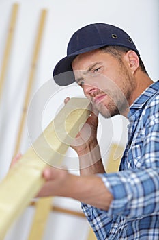 concentrated young male carpenter checking board photo
