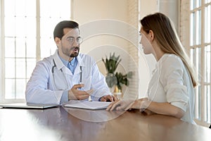 Concentrated young male general practitioner consulting patient.