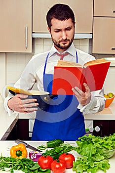 Concentrated young man reading cookbook