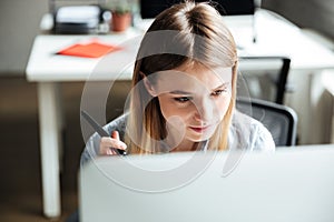 Concentrated young woman work in office using computer