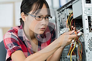 Concentrated young woman working with pc cables
