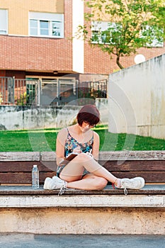 Concentrated young writer and student woman writing outdoors for inspiration, constancy concept photo
