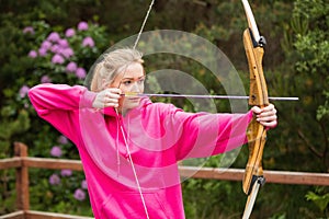 Concentrating blonde practicing archery