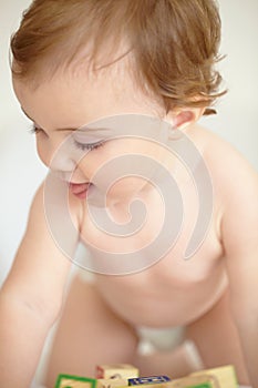Concentrating on her next construction. Closeup image of a cute little baby playing with building blocks.