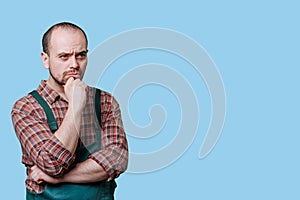 Concentrating, pensive workman in studio Serious meditative man in portrait,