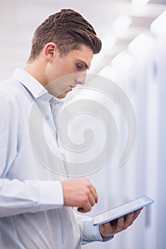 Concentrating young technician working with his tablet