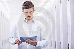 Concentrating young technician working with his tablet