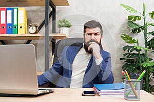 Concentration and focus. Man bearded boss sit office with laptop. Manager solving business problems. Businessman in
