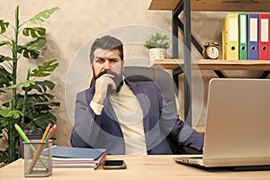 Concentration and focus. Man bearded boss sit office with laptop. Manager solving business problems. Businessman in