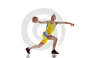 Concentration and motivation to win. Young girl, basketball player in motion, training against white studio background