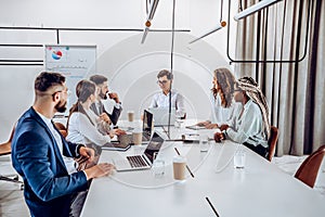 Concentration at work. Successful young business people are sitting together in an office at a business meeting discussing a work