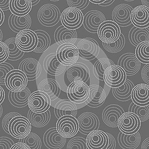 Concentric circles with dotted outline in two colors. Seamless geometric pattern on dark gray background. Vector colorless image