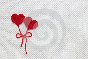 The concept for 14 February, romantic Valentine day. Love affair, love story. Red crochet wool heart and ribbon on white crochet