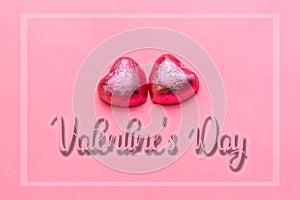 Concept of 14 february or Valentine Day. Chocolate bonbons hearts in a pink wrapper. Pink background. Valntine`s Day and frame