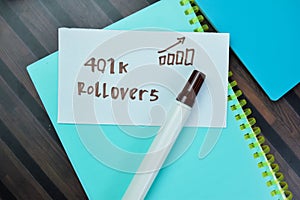 Concept of 401k Rollovers write on sticky notes isolated on Wooden Table