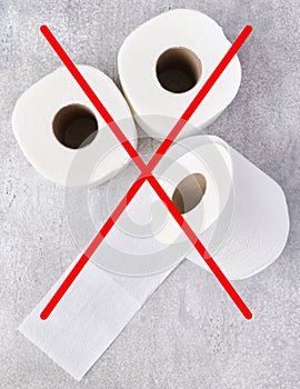 Concept of abandoning disposable toilet paper due to rising costs in crisis, toilet paper rolls crossed with a red cross