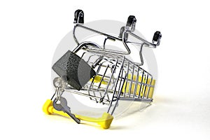 the concept of abandoning the purchase of reasonable consumption is an inverted shopping cart with a padlock on a white