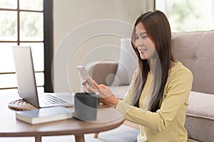 Concept of activity in home, Young woman surf social media on phone while sitting to relax on floor