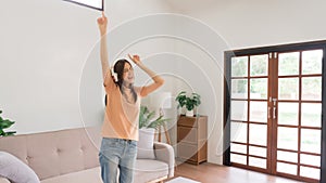 Concept of activity in home, Young woman wears headphone listening music and dancing in living room