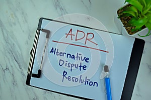 Concept of ADR - Alternative Dispute Resolution write on a paperwork isolated on Wooden Table