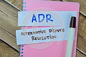 Concept of ADR - Alternative Dispute Resolution write on sticky notes isolated on Wooden Table