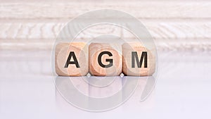 concept of AGM word on wooden cubes, wooden background