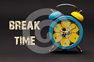 Concept,alarm clock with break time phrase written on black back